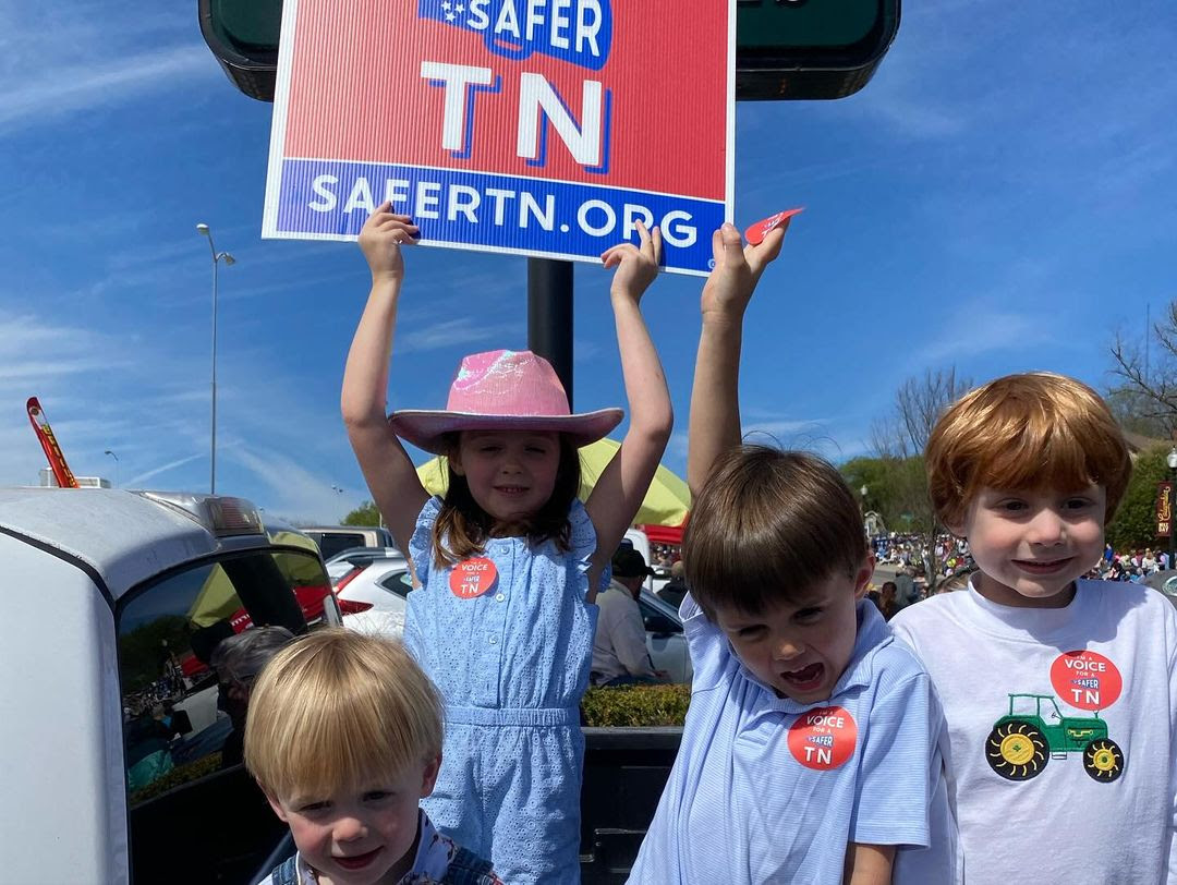 children holding a Voices for a Safer TN sign
