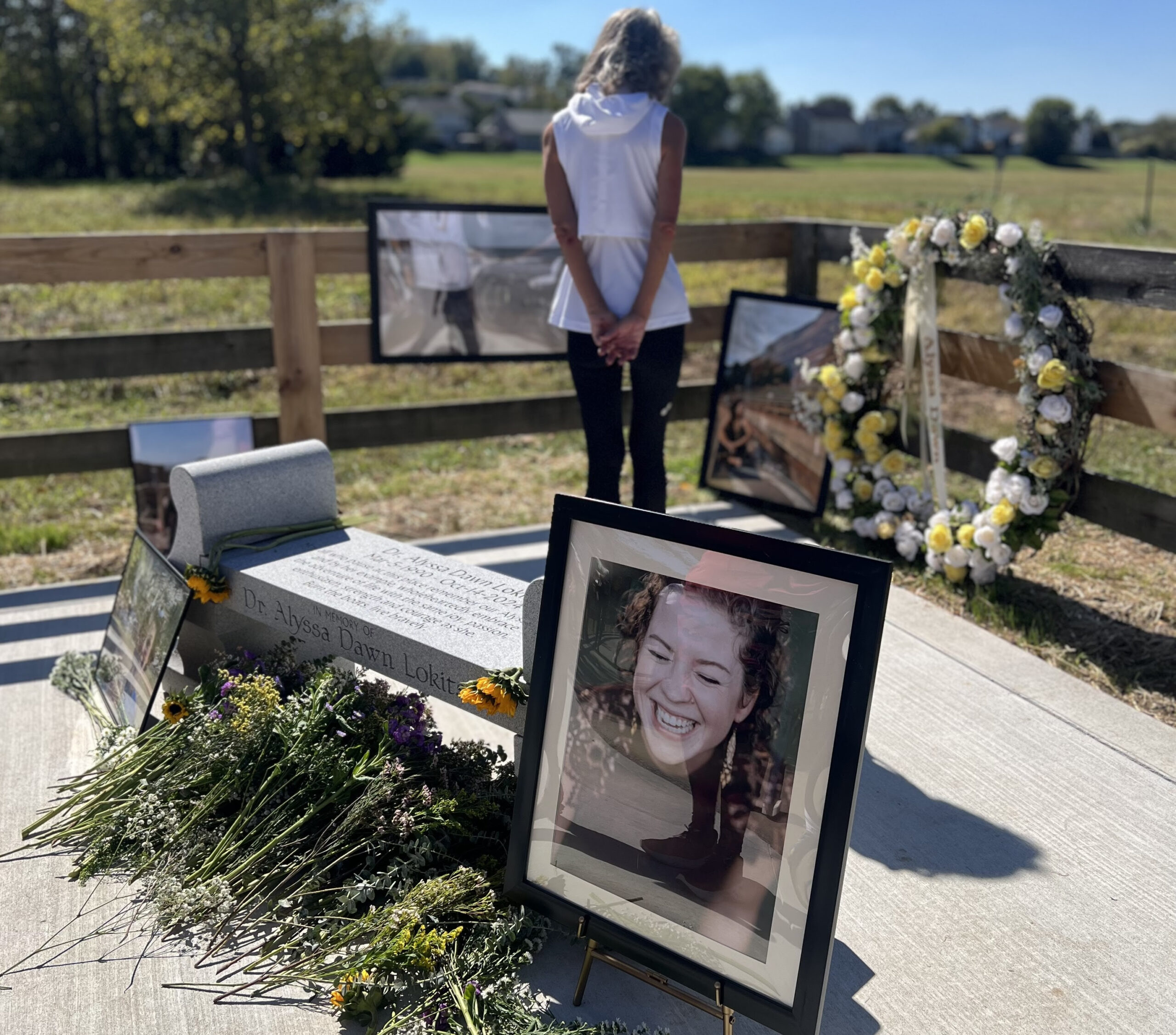 a woman looks at memorials left in memory of the Alyssa Lokits